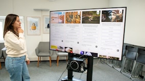 a woman standing in front of a large poster