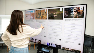 a woman pointing to a poster on a wall
