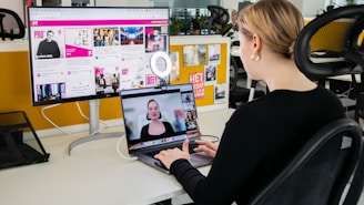 a woman sitting at a desk using a laptop computer