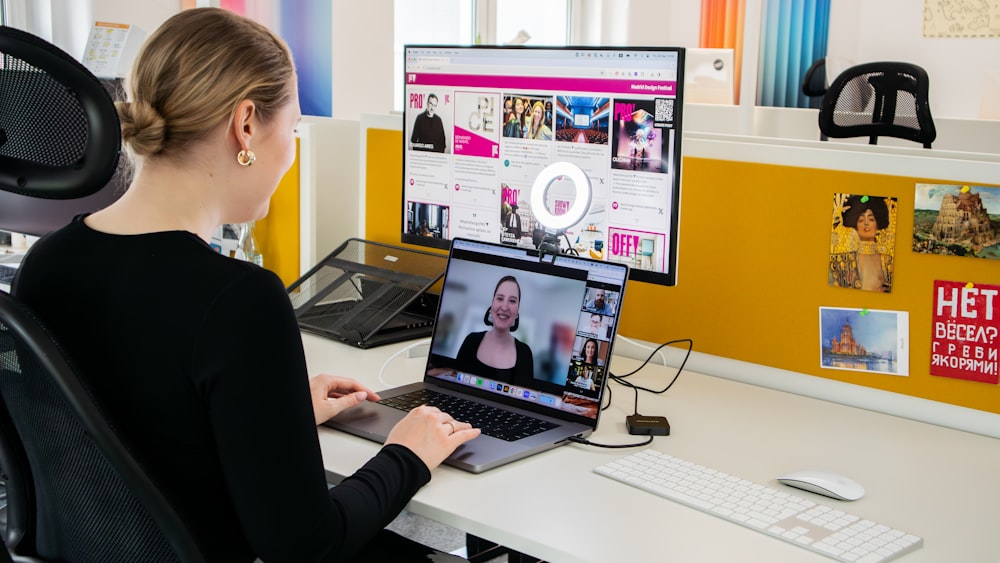 a woman sitting at a desk using a laptop computer