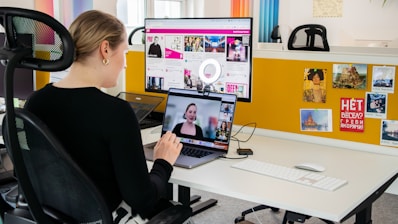 a woman sitting at a desk with a laptop computer