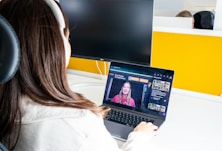 a woman sitting in front of a laptop computer
