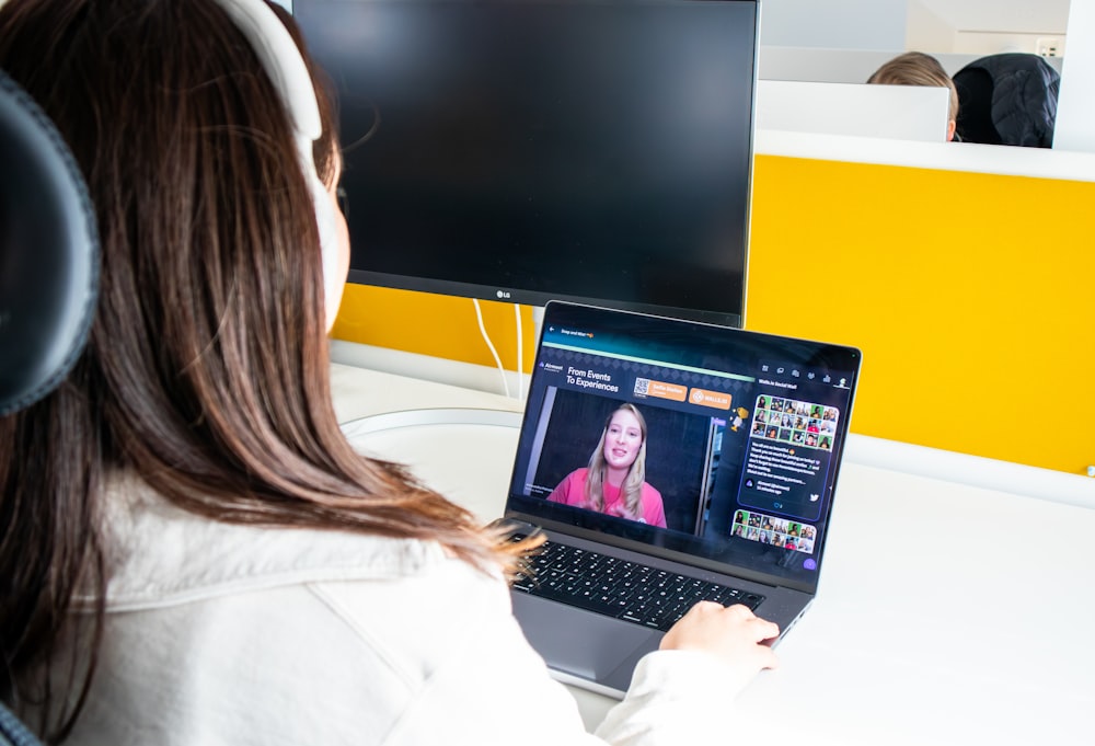 a woman sitting in front of a laptop computer