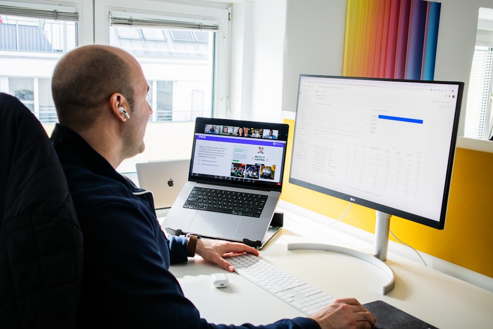 a man sitting in front of a computer monitor