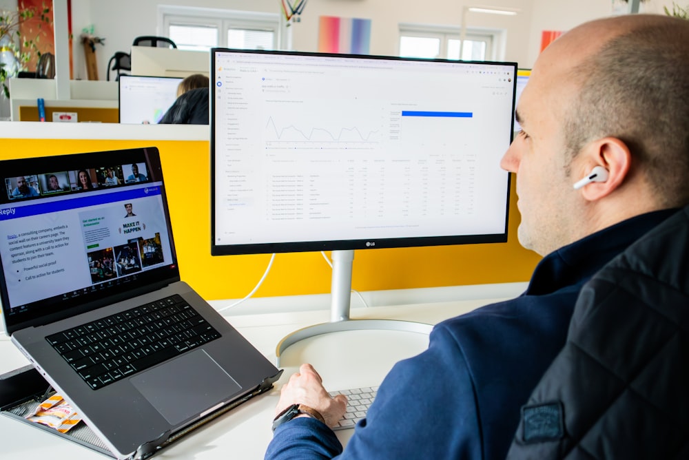 a man sitting in front of a computer monitor