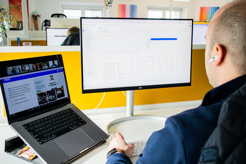 a man sitting in front of a computer monitor