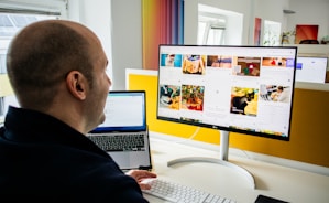 a man sitting in front of a computer monitor