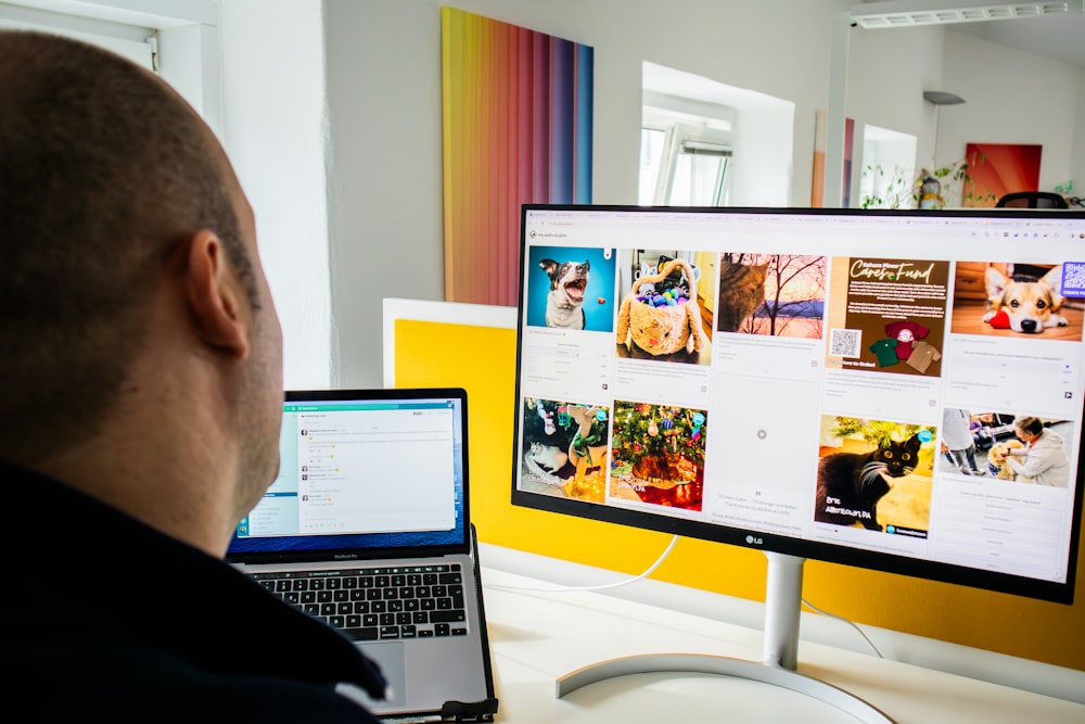 a man sitting in front of a computer monitor