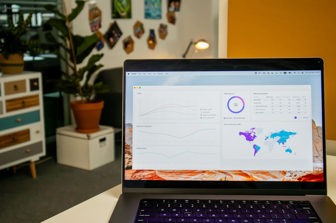 A laptop on a desk showing an analytics dashboard with traffic charts