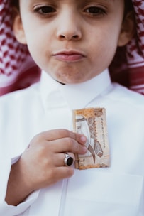 a young boy wearing a white shirt and a hat