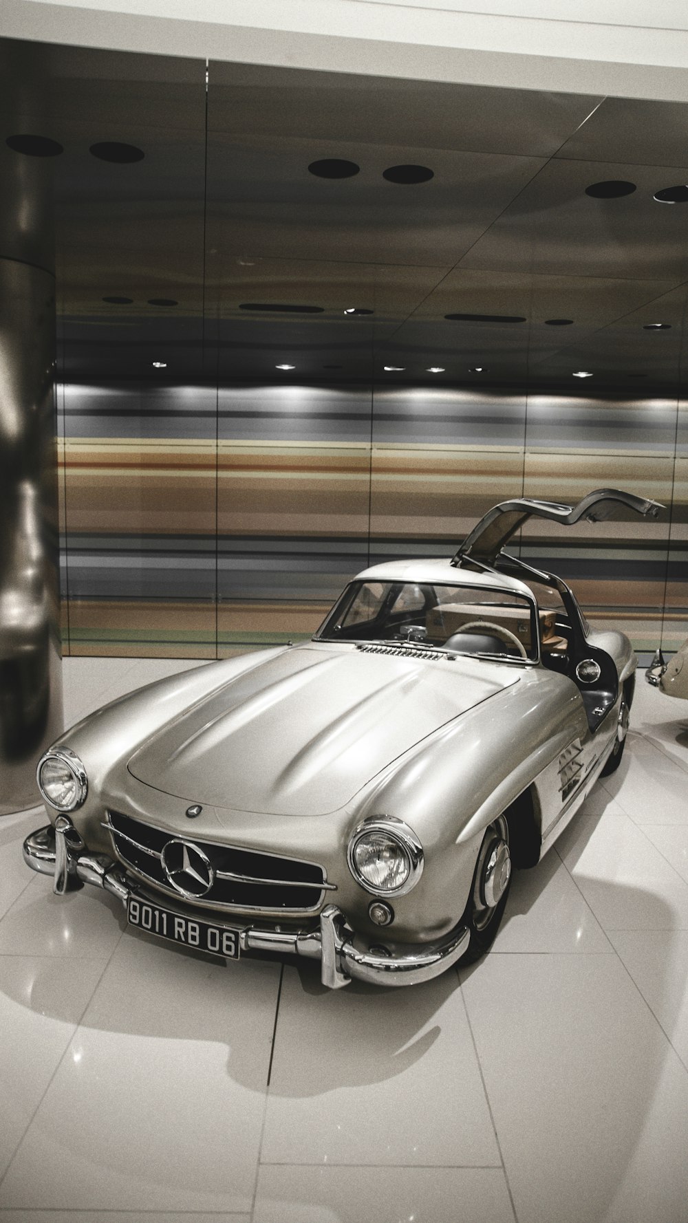 Un deportivo Mercedes plateado aparcado en una sala de exposición