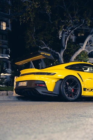 a yellow sports car parked on the side of the road