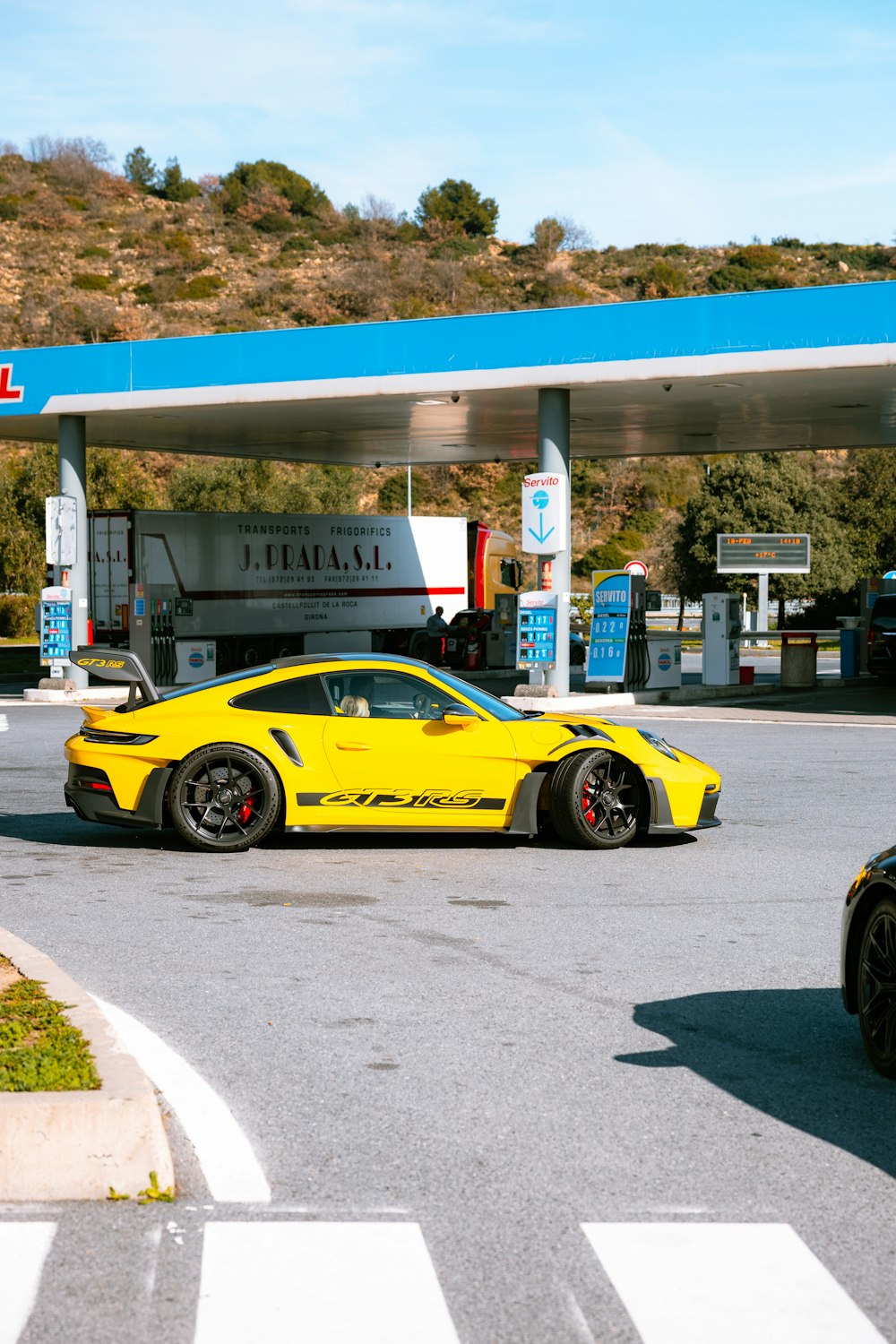 a yellow sports car at a gas station