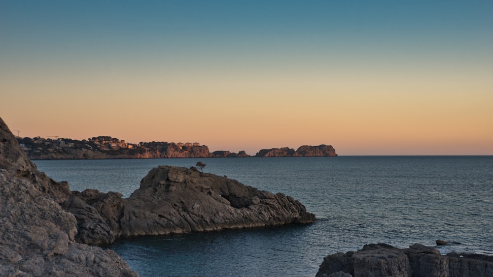 a body of water with rocks in the foreground