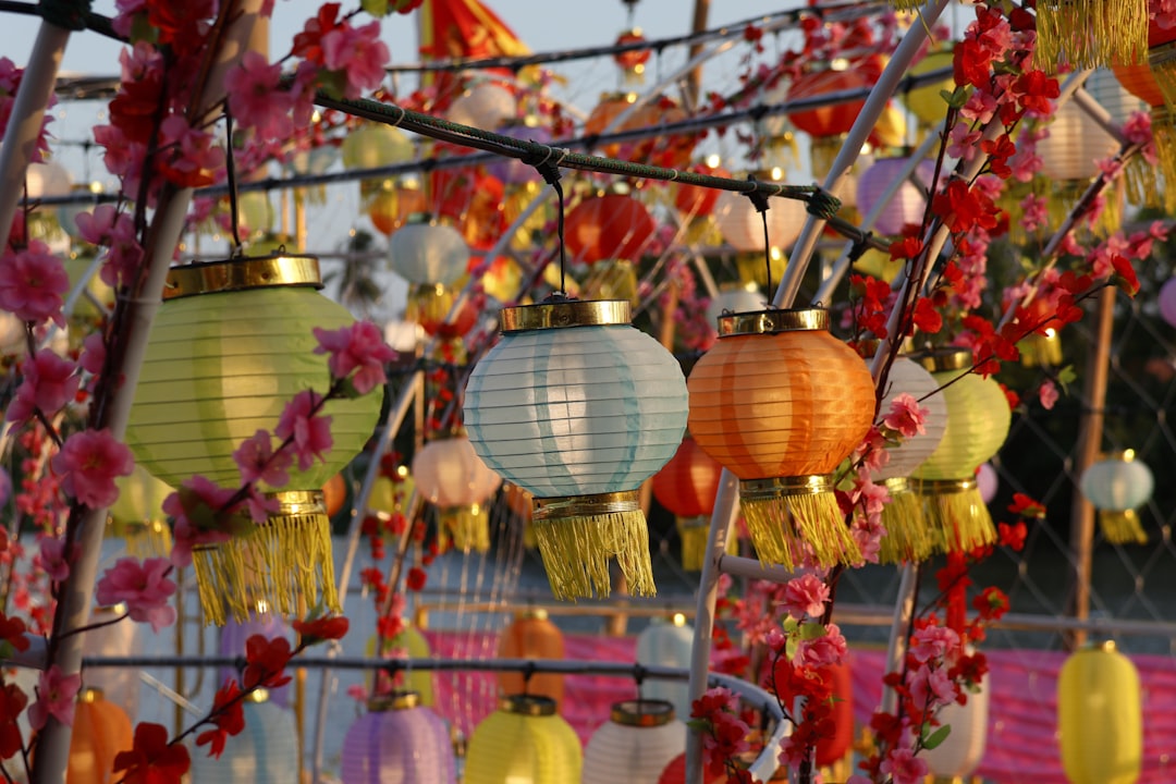 a bunch of colorful lanterns hanging from a pole, Lanterns