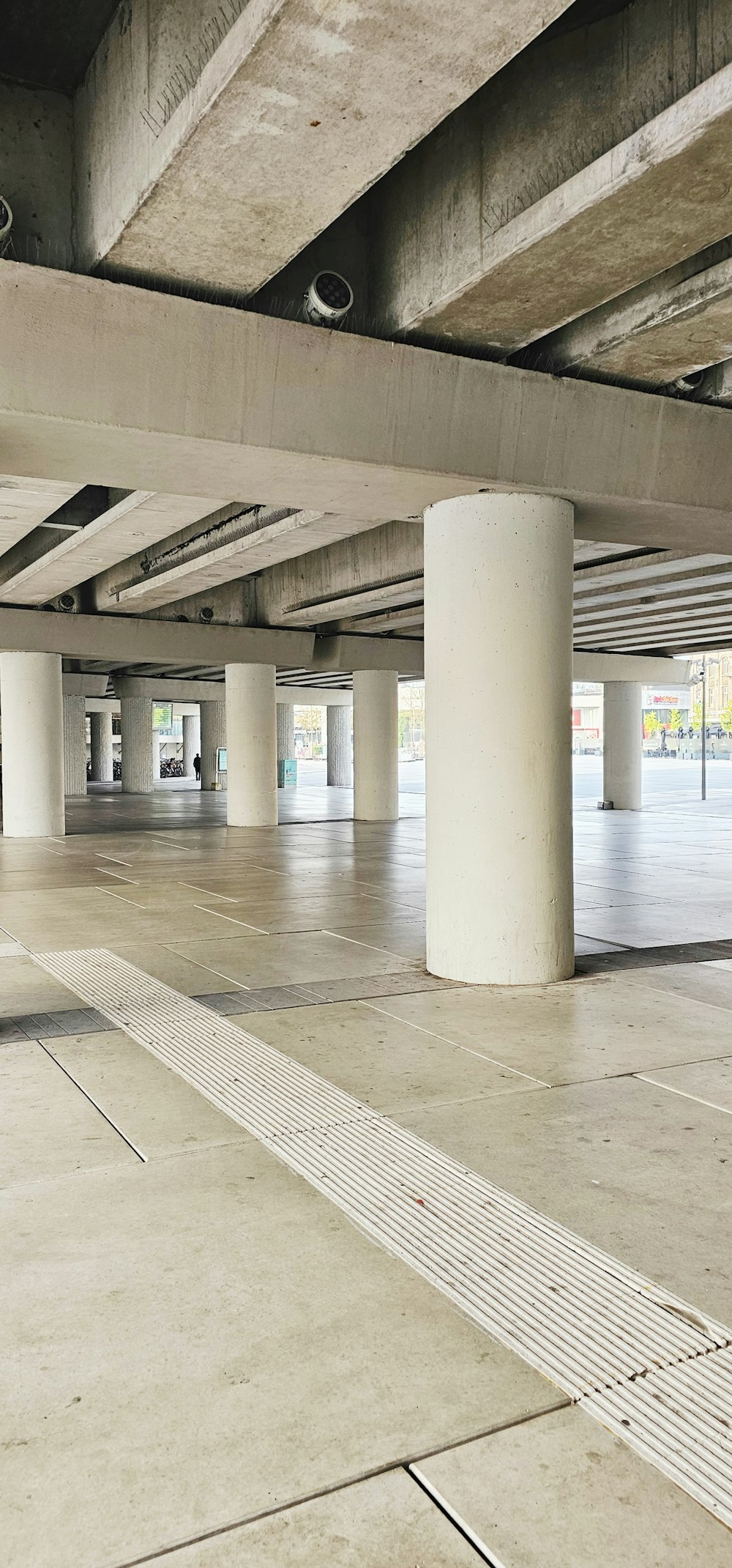 a parking garage filled with lots of white pillars