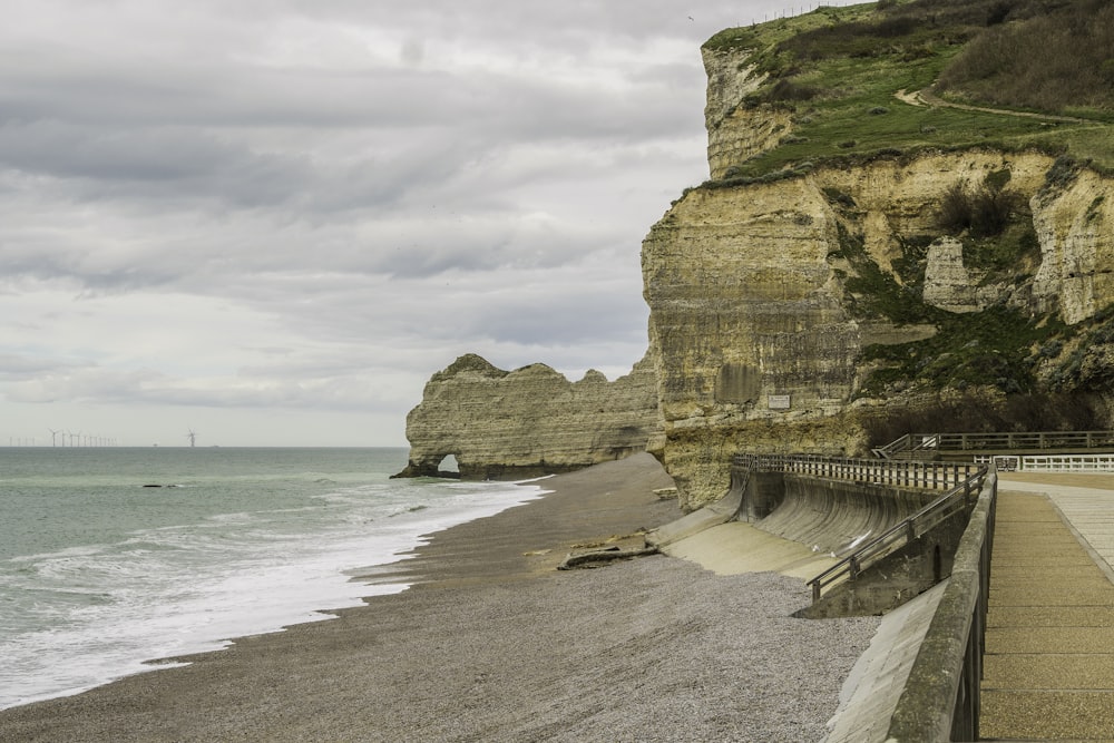 a view of a beach with a cliff in the background