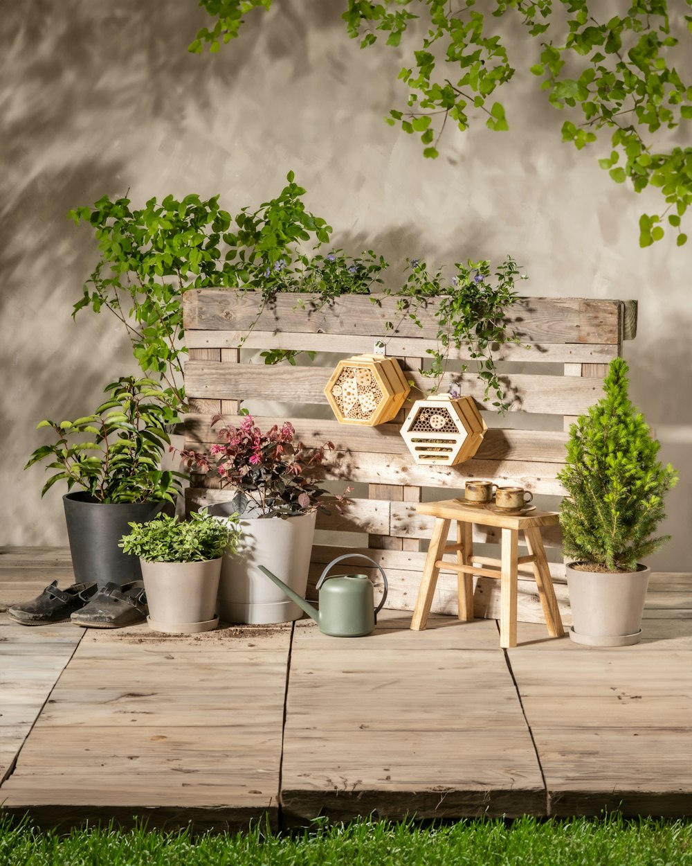 a wooden bench sitting next to a bunch of potted plants