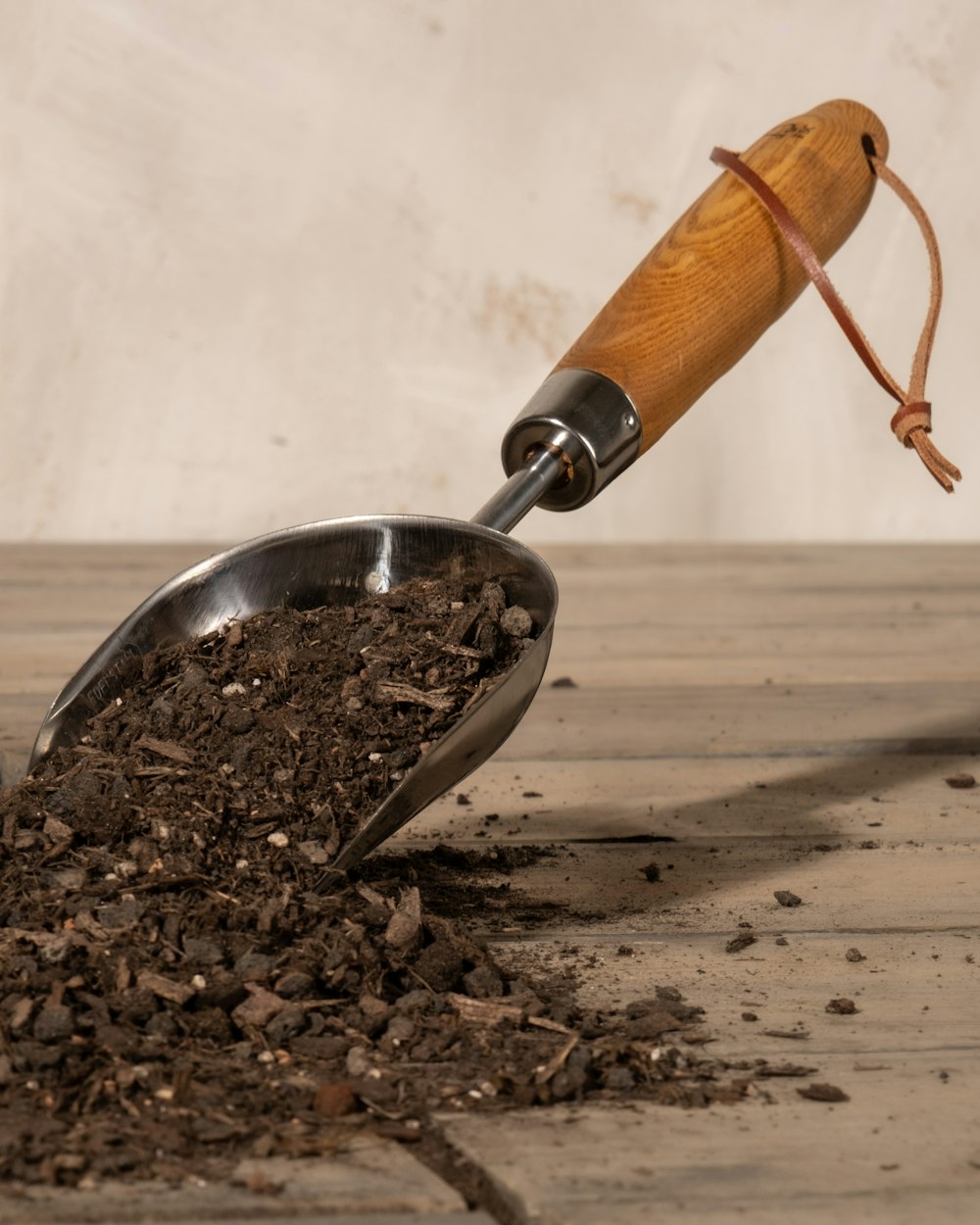 a scoop full of dirt with a wooden handle