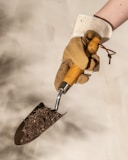 a person holding a shovel with dirt on it