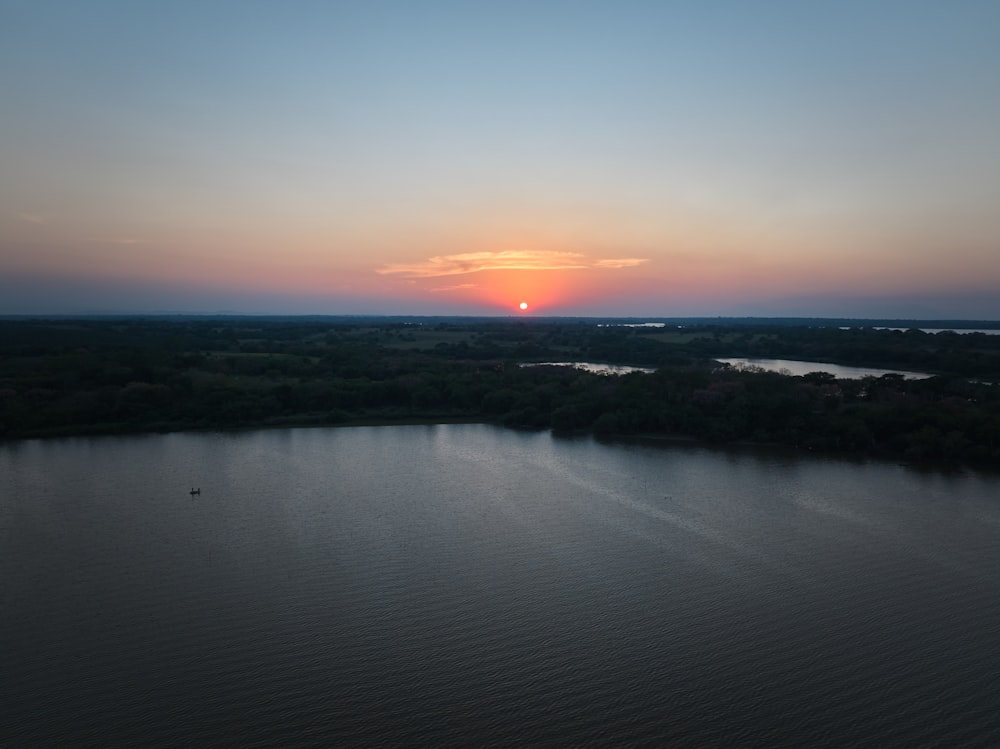 the sun is setting over a body of water