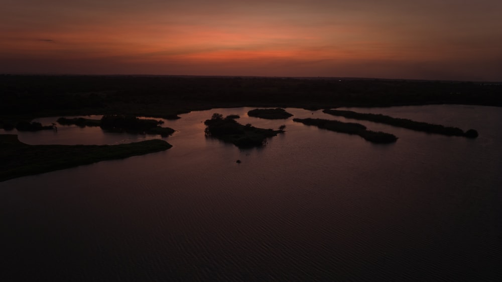 a body of water with a sunset in the background