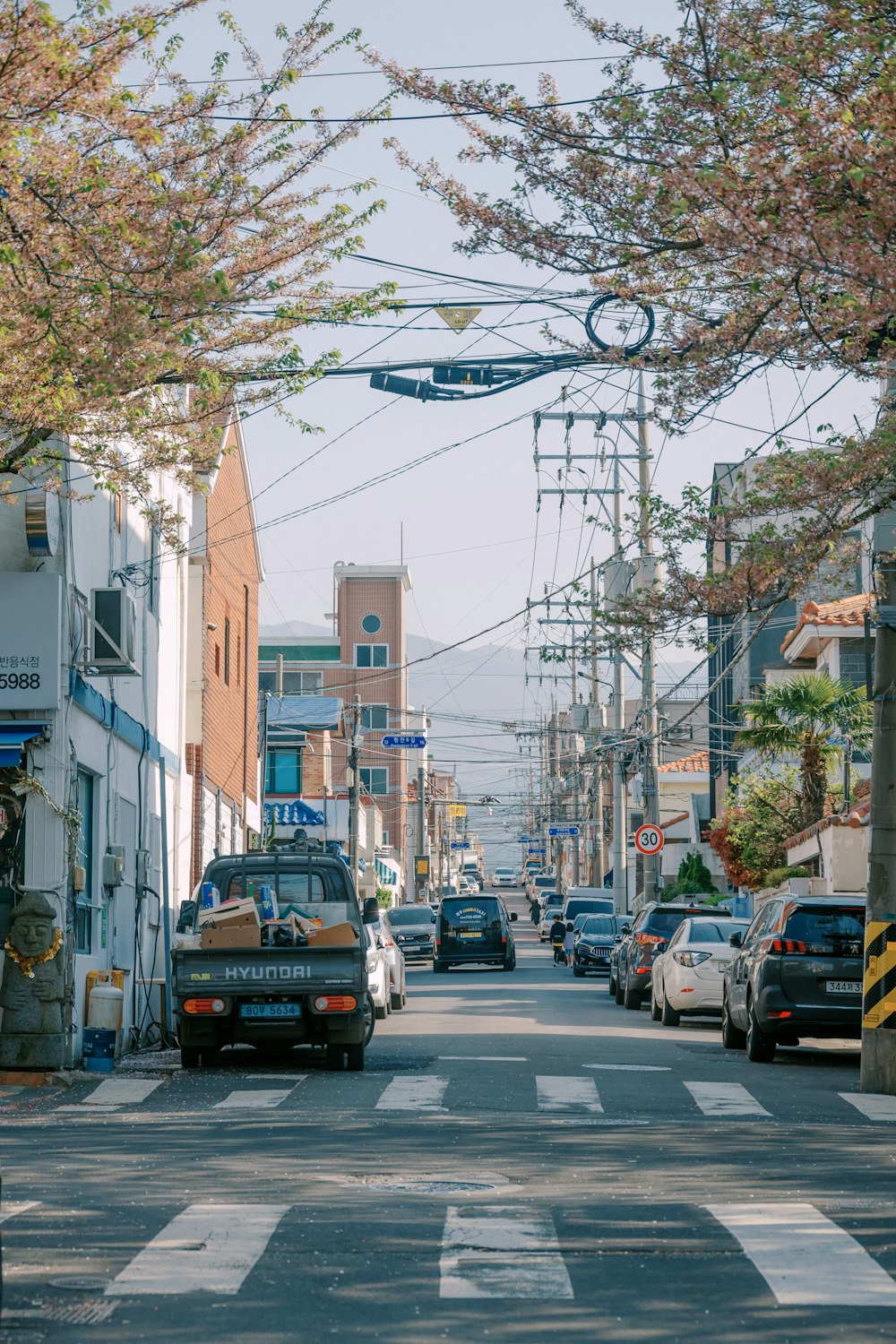 a city street with cars parked on both sides of the street