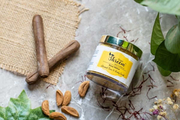 A jar of nut butter next to a cinnamon stick