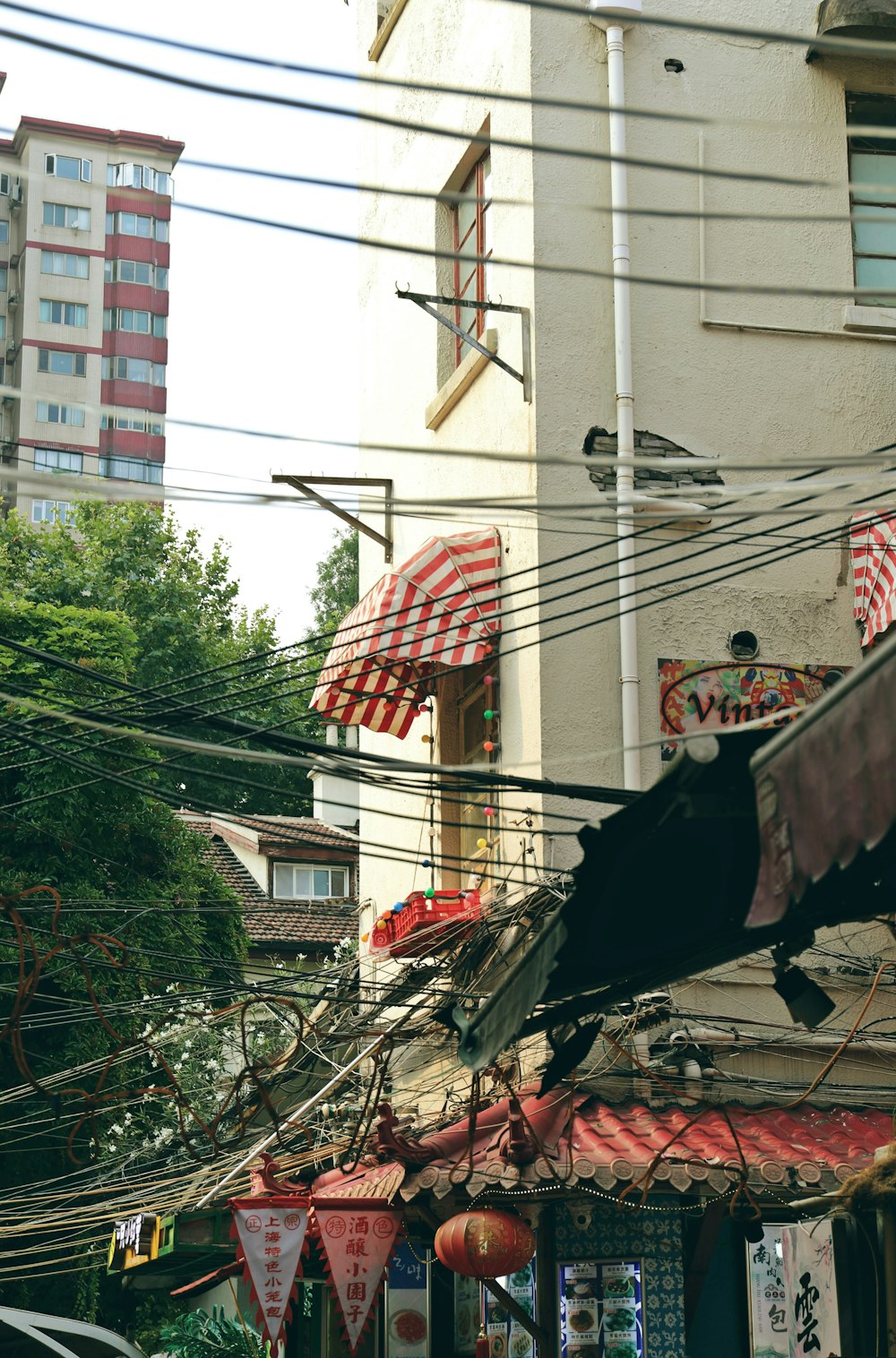 a black cat sitting on top of a building next to power lines