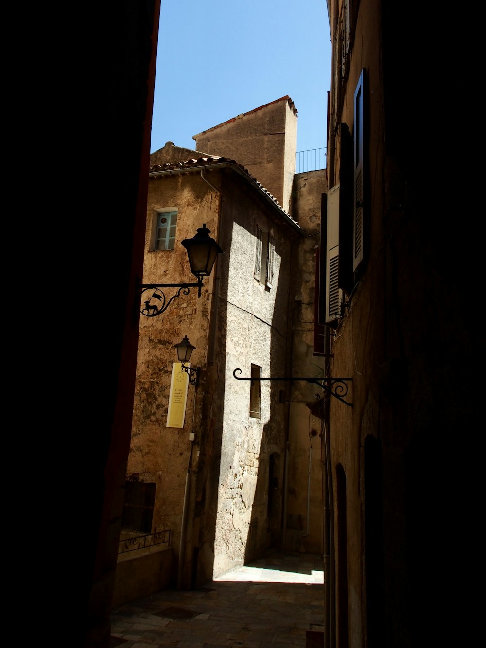 a narrow alley way with a cross on the wall