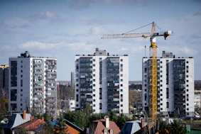 a crane is standing in front of some tall buildings