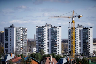 a crane is standing in front of some tall buildings