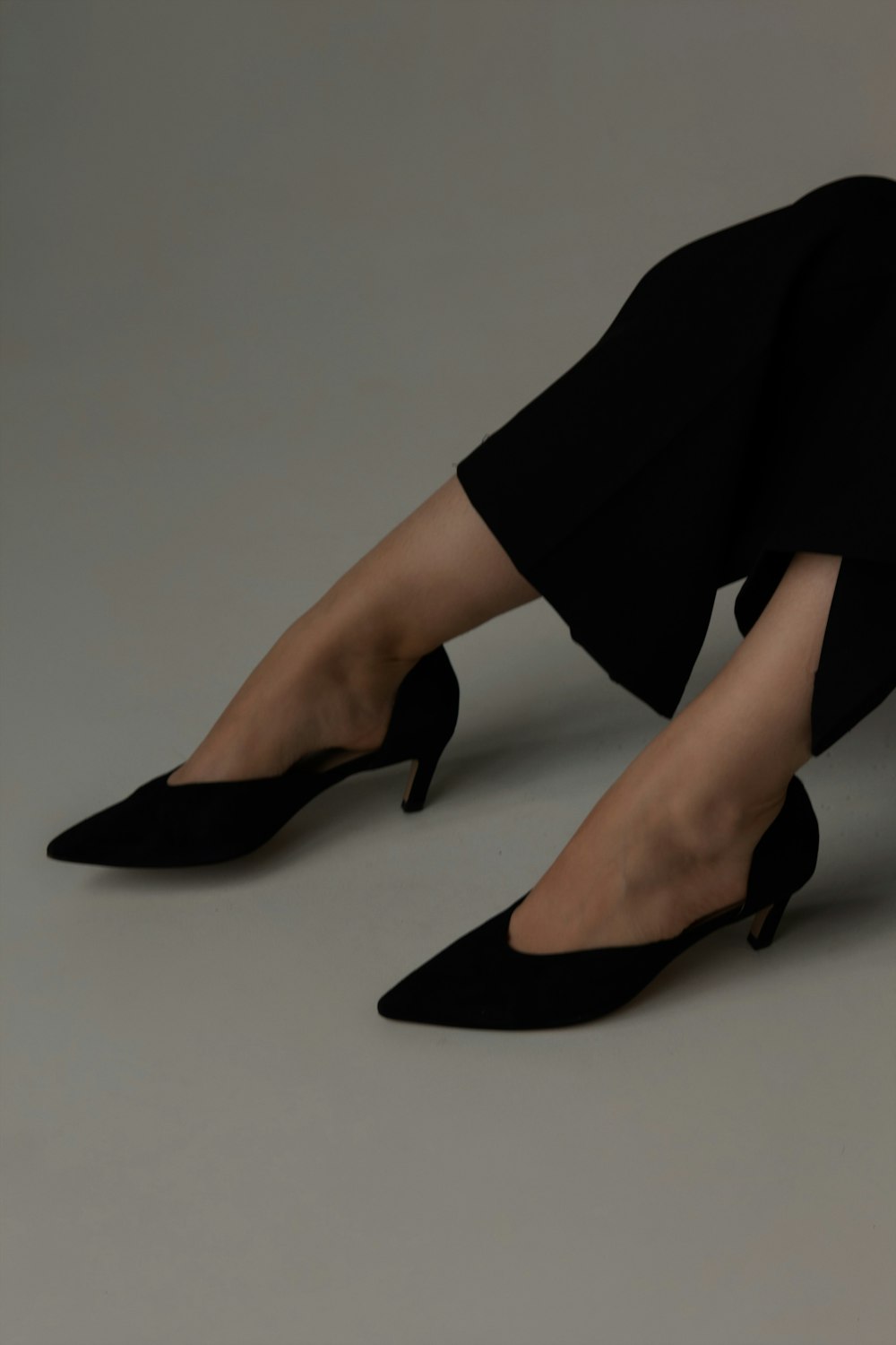 a woman wearing black high heels and a black dress