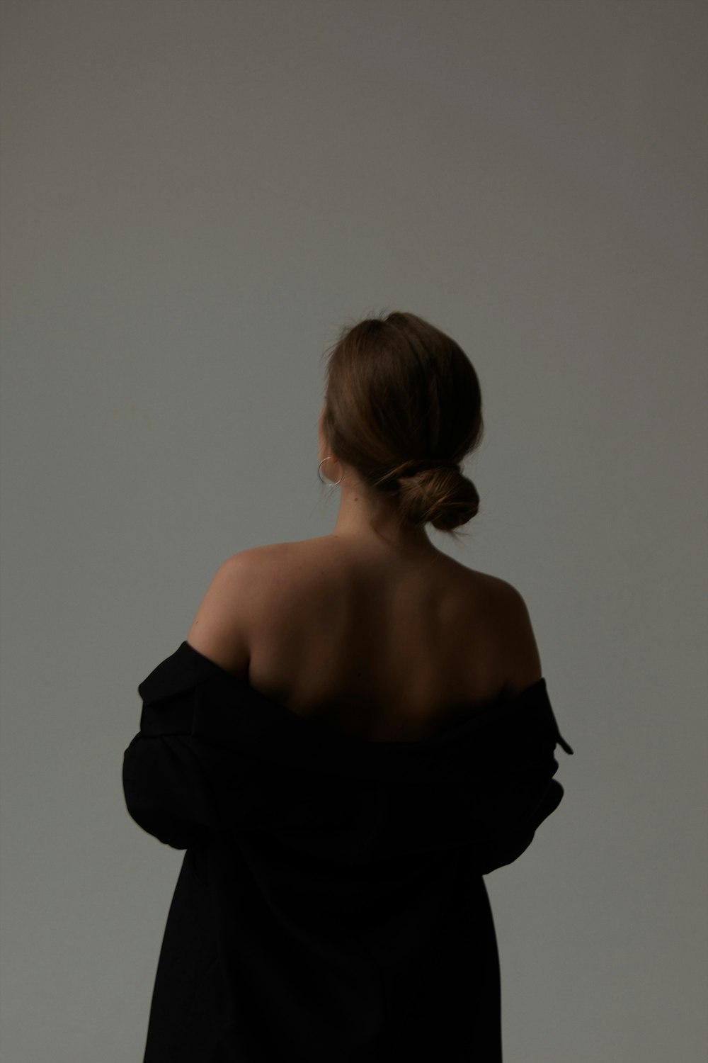 a woman in a black dress with her back to the camera