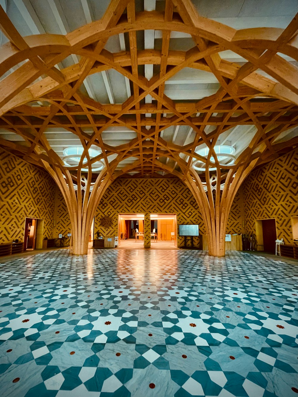 a large room with a tiled floor and wooden beams