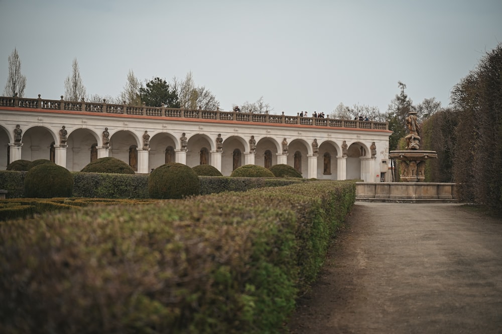 a large white building with a fountain in the middle of it