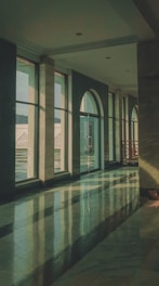 an empty lobby with large windows and marble floors