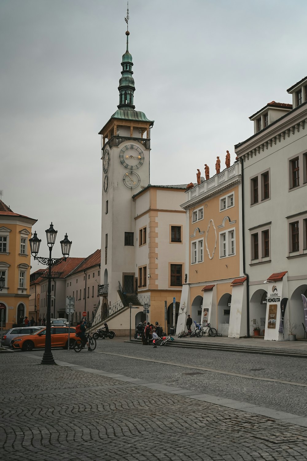 a clock tower in the middle of a cobblestone street