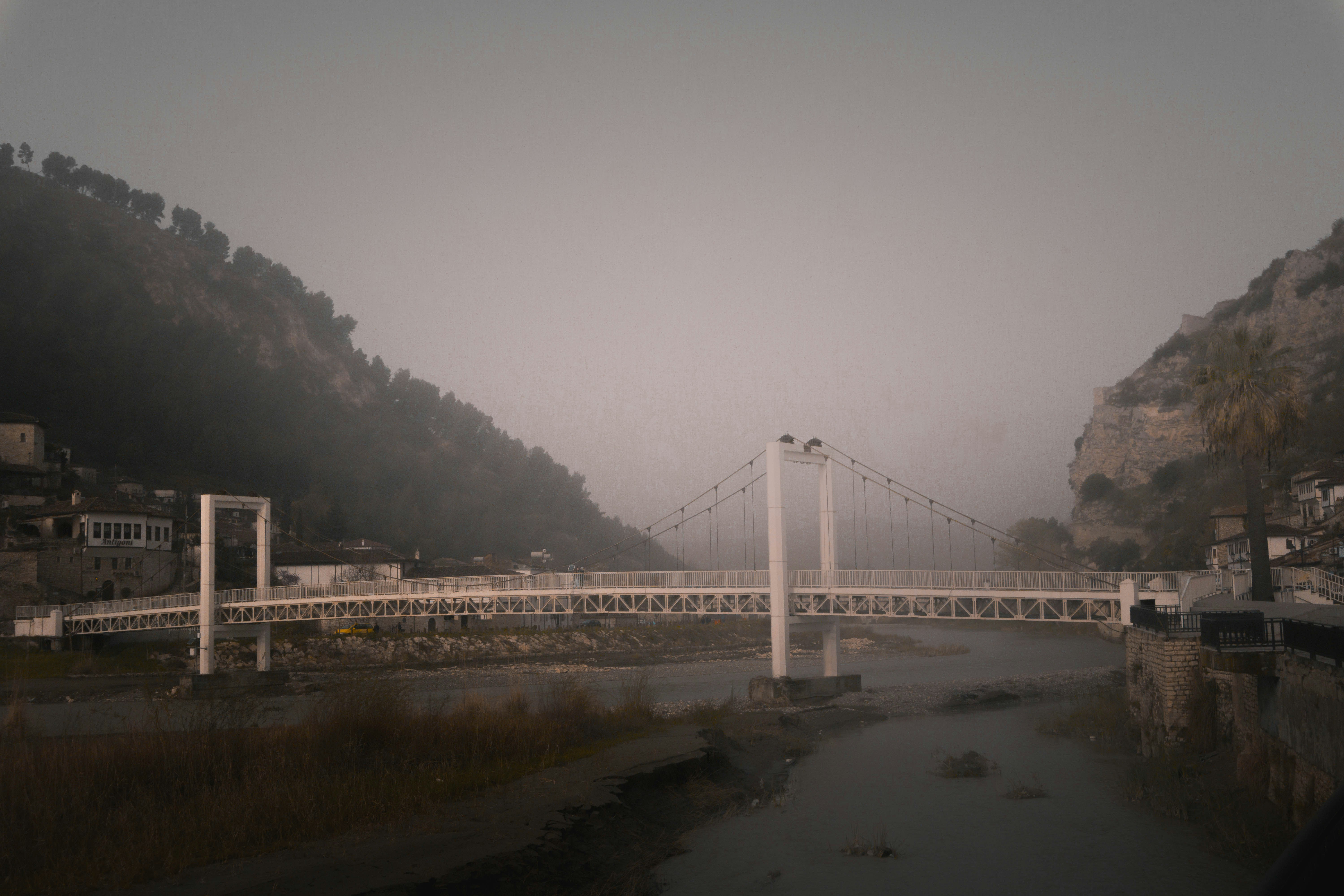 a bridge over a body of water with a mountain in the background
