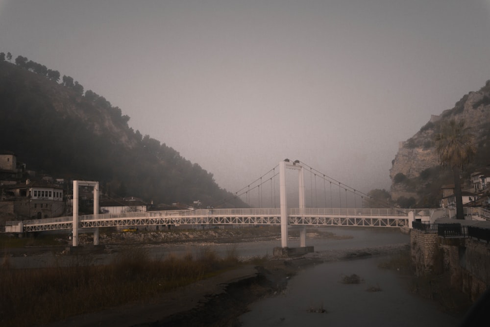 a bridge over a body of water with a mountain in the background