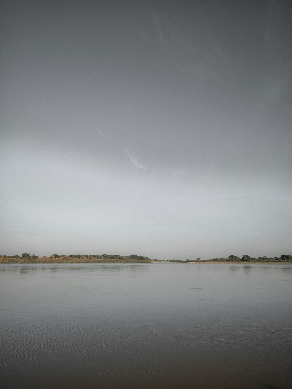 a large body of water sitting under a cloudy sky