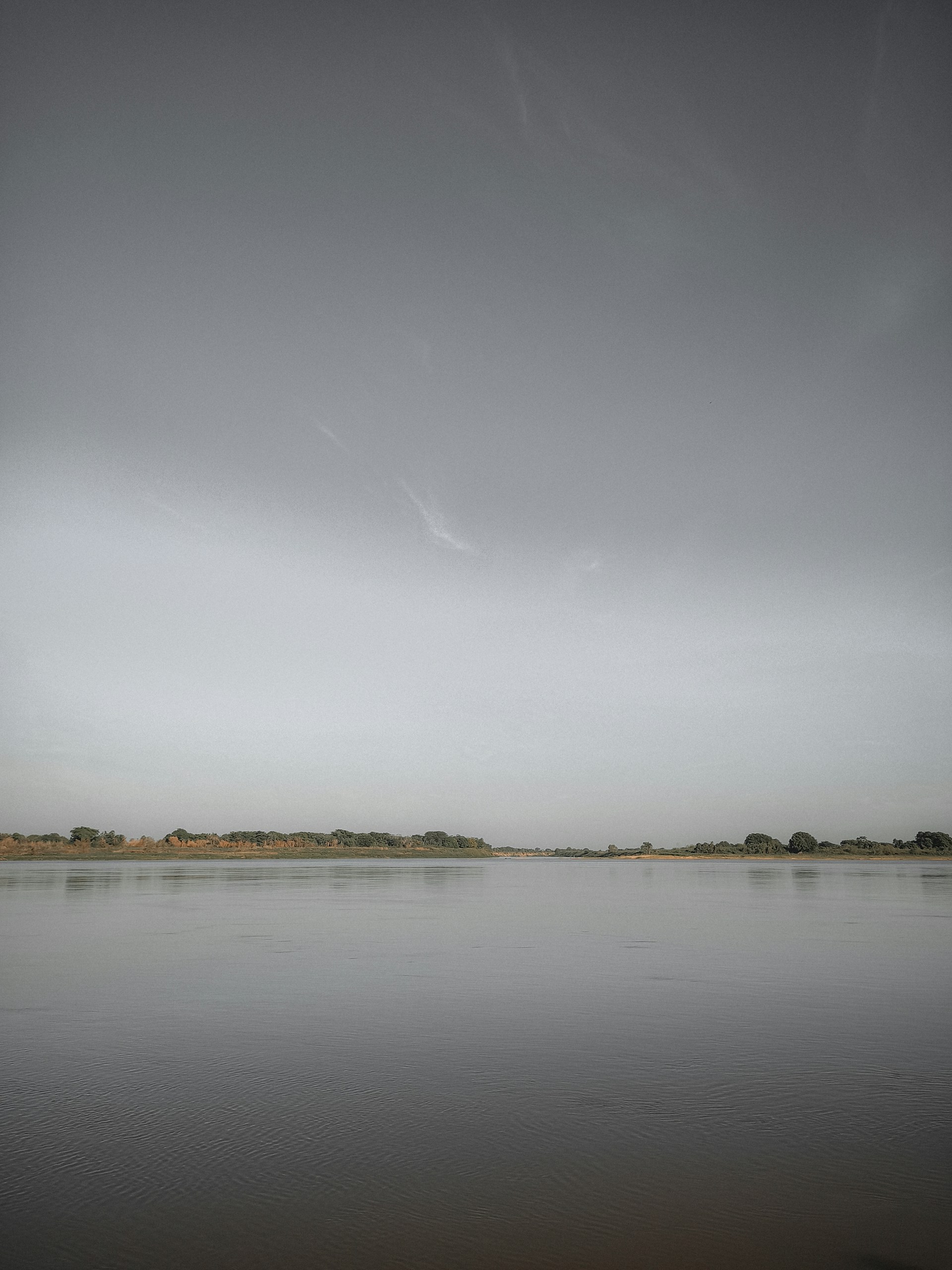 a large body of water sitting under a cloudy sky