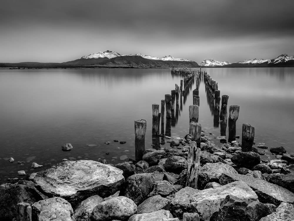 a black and white photo of a dock on a lake