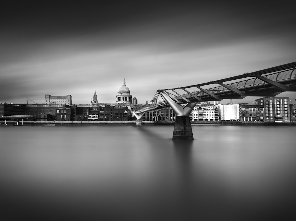 une photo en noir et blanc d’un pont au-dessus de l’eau