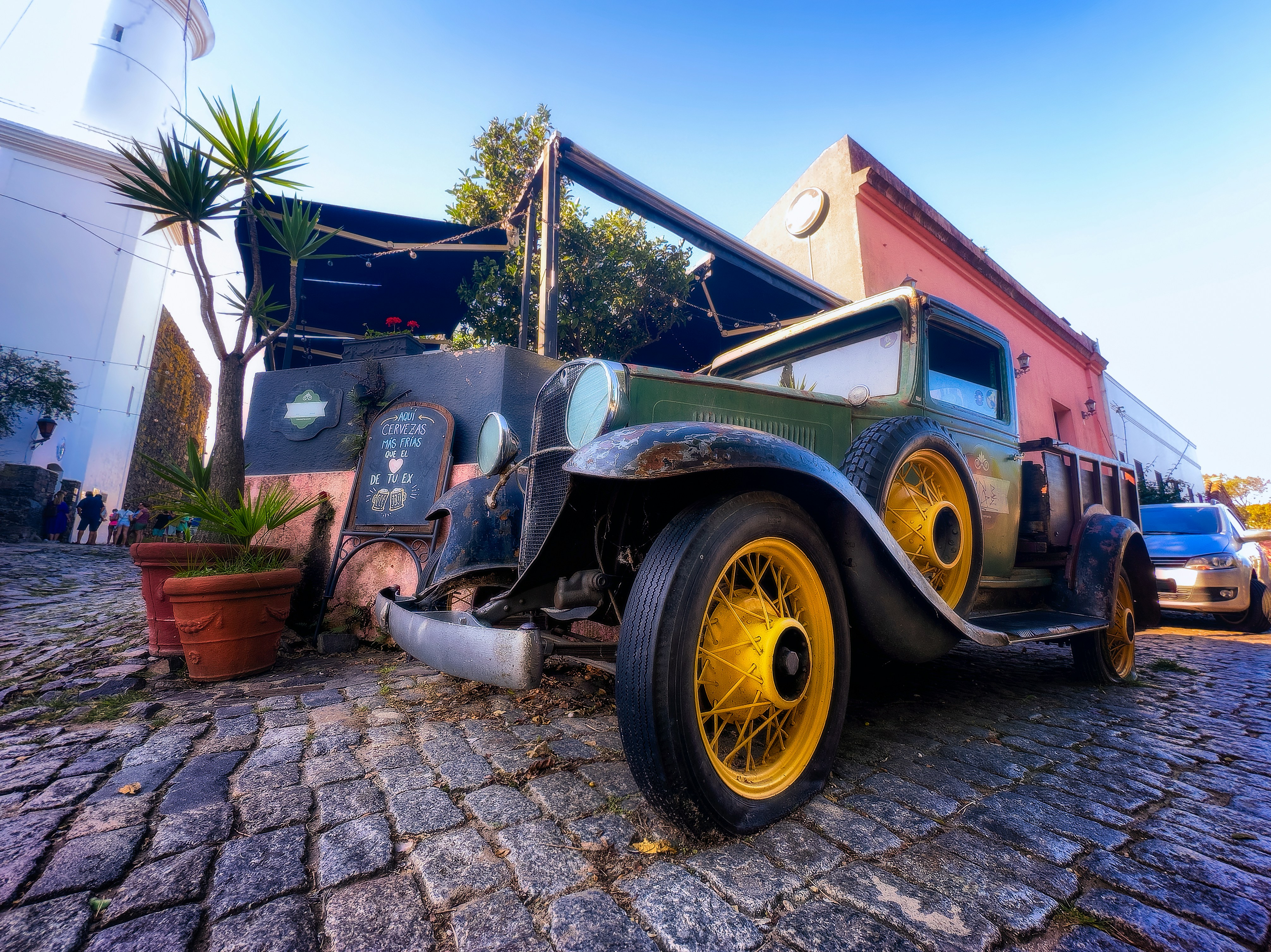 Une vieille voiture est garée devant un immeuble