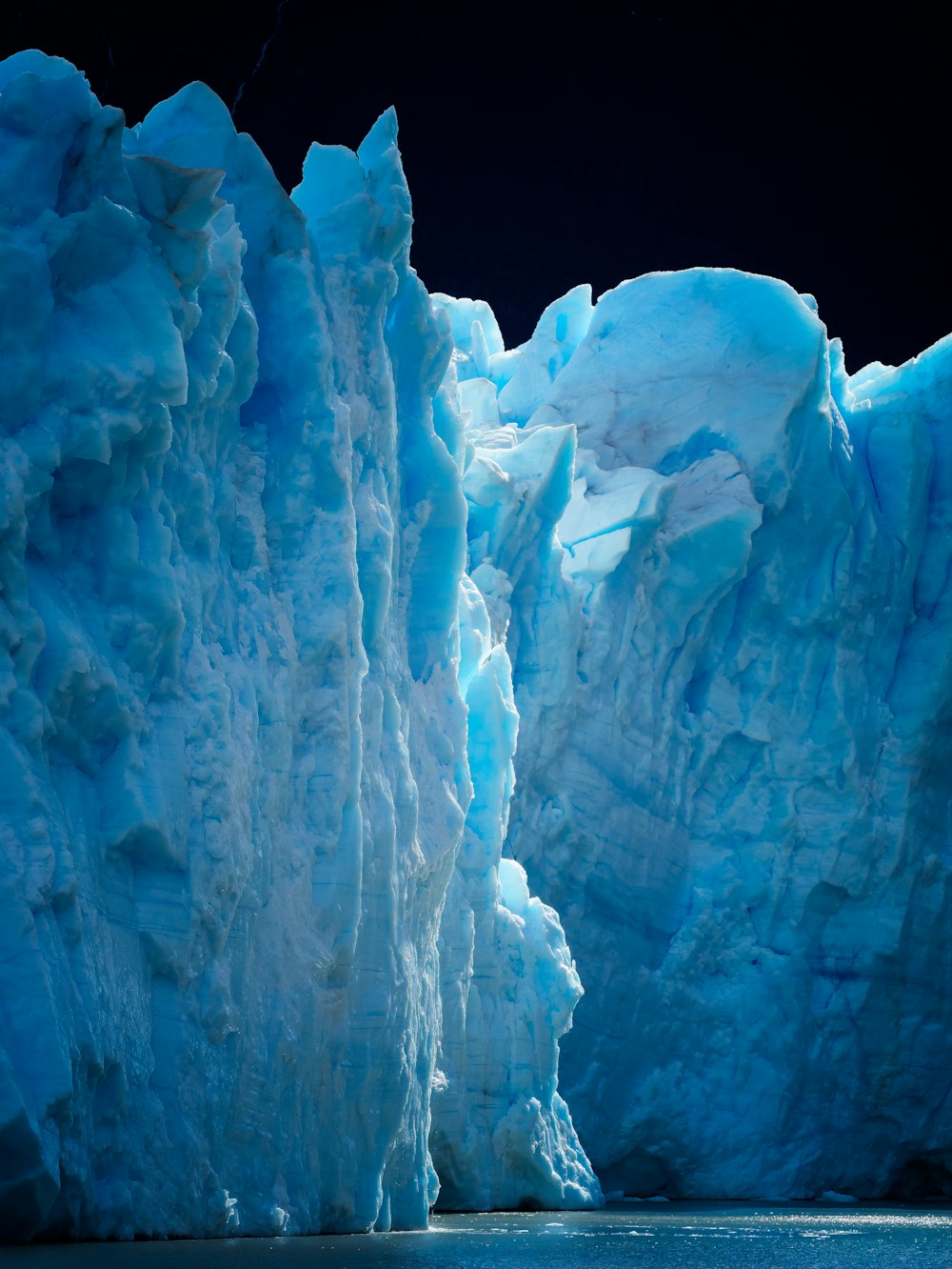 a large iceberg towering over a body of water