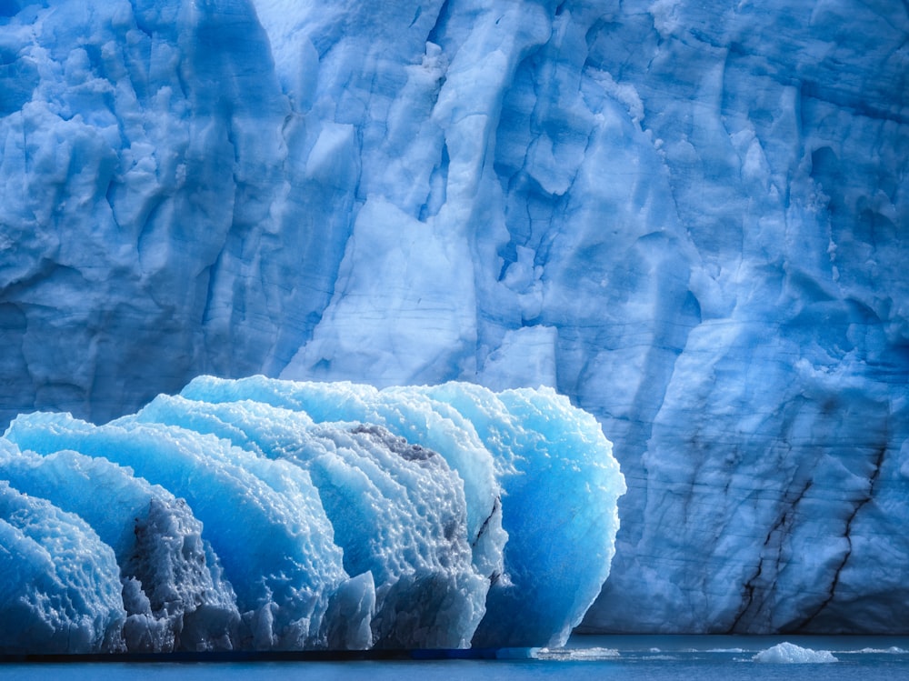 a large blue iceberg floating in the water