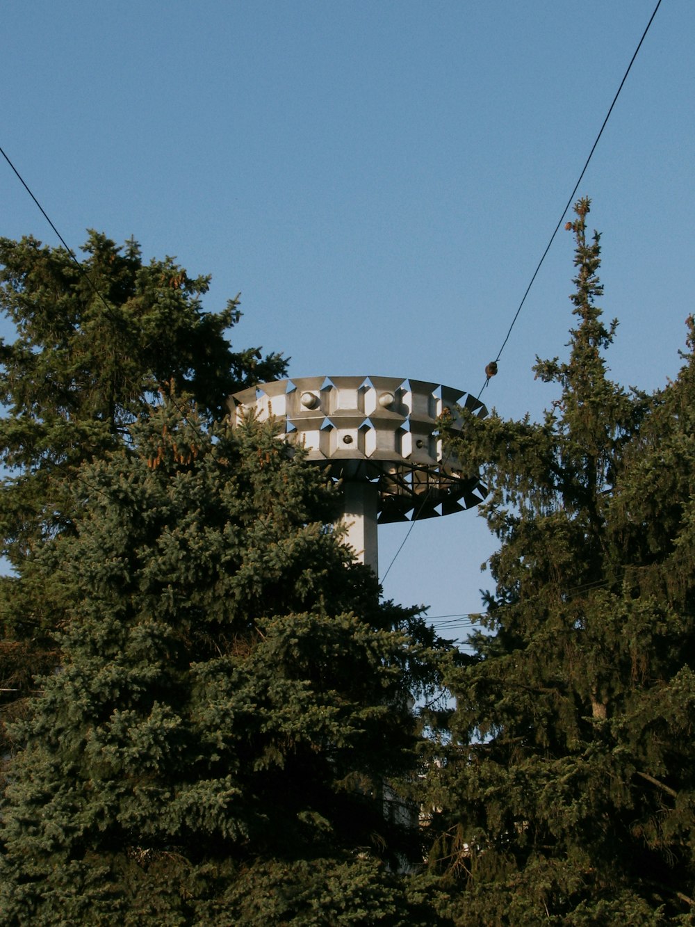 a person riding a ski lift over a forest
