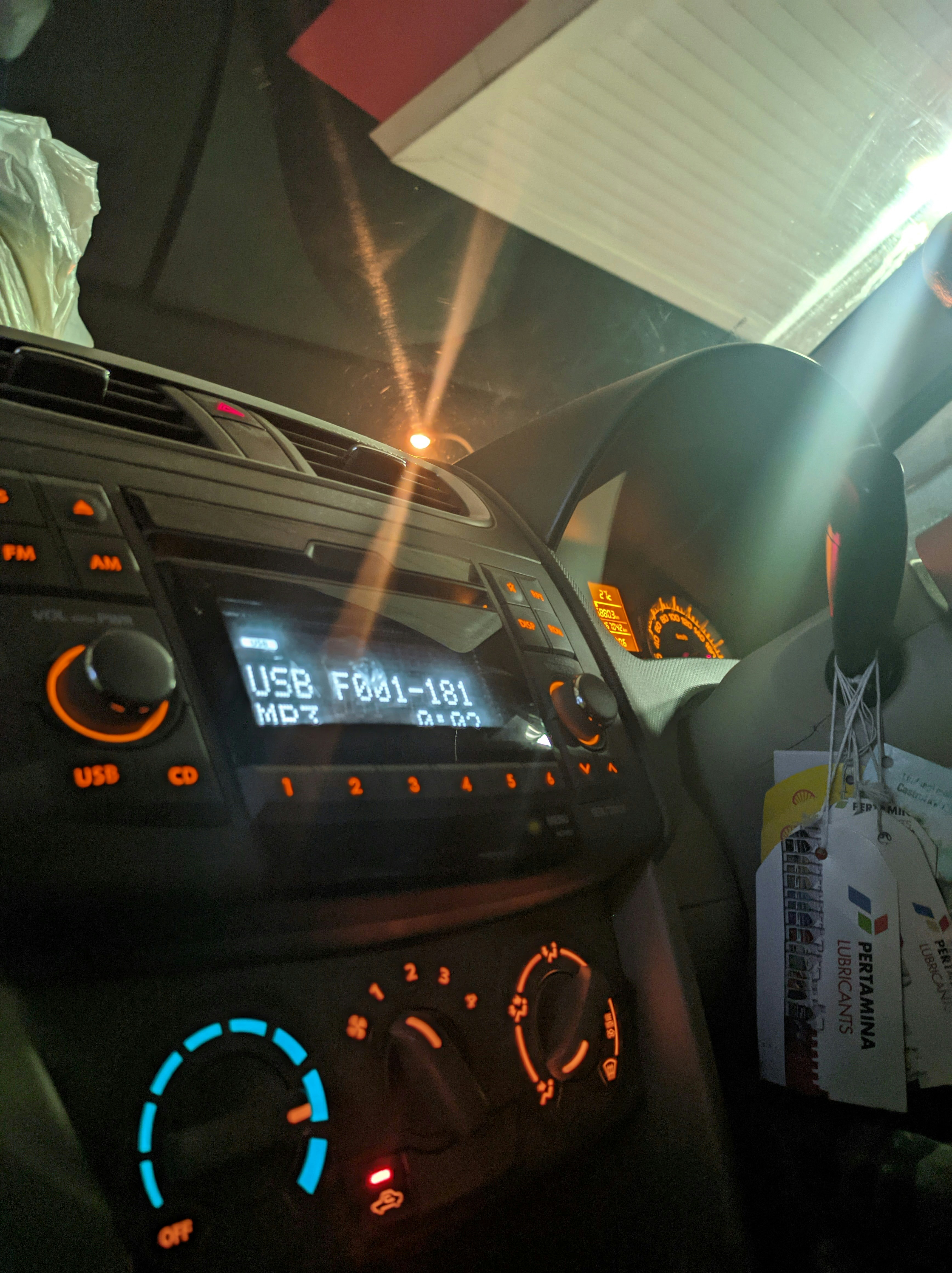 Kenwood car stereo unit with illuminated controls and USB port visible