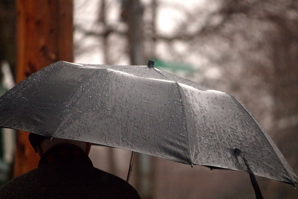 Una persona sosteniendo un paraguas bajo la lluvia